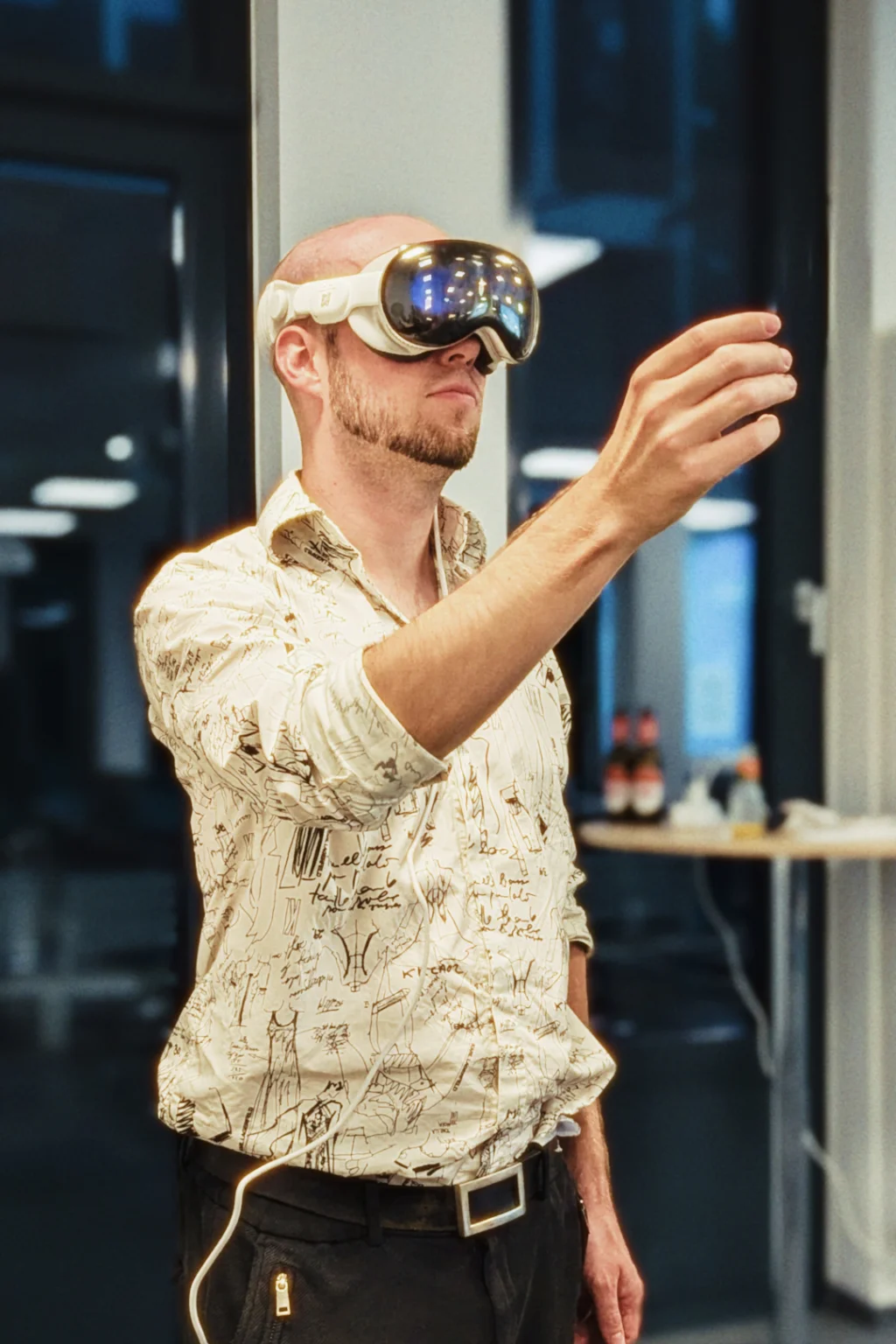 A young man with XR glasses makes a gesture.