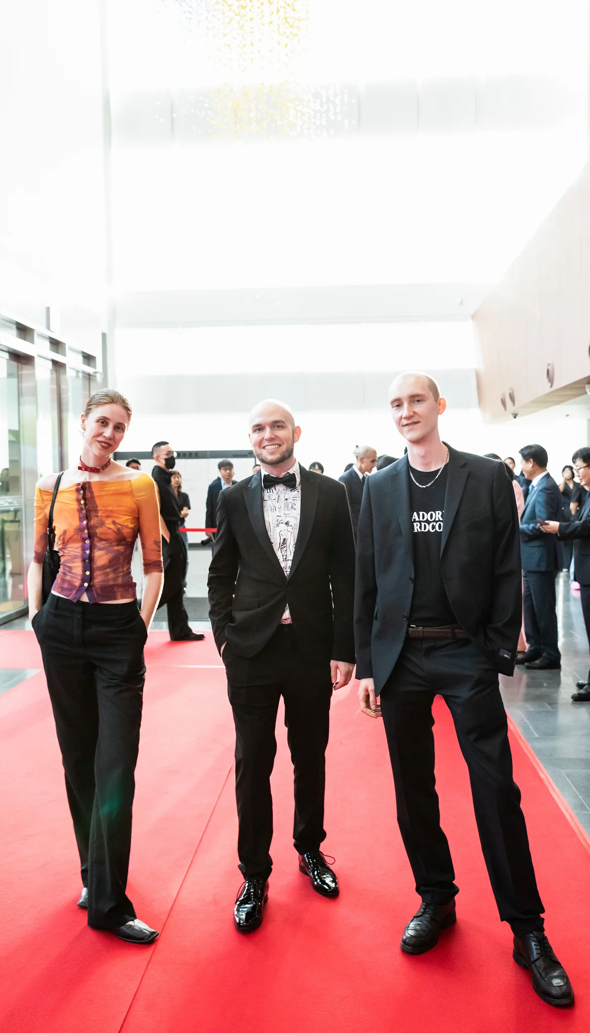 Young people dressed up on a red carpet.